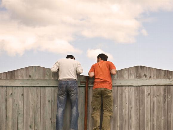 two men looking over fence