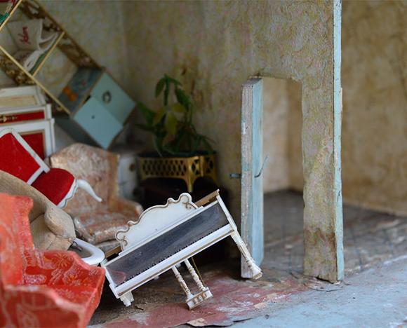 piled up furniture in worn down doll house